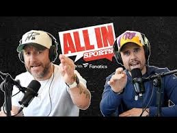 Two men wearing caps and headsets pointing at camera with ALL IN text and Fanatics logo on dark background